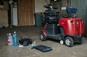Mobility scooter in a garage beside emergency supplies laid out on the floor